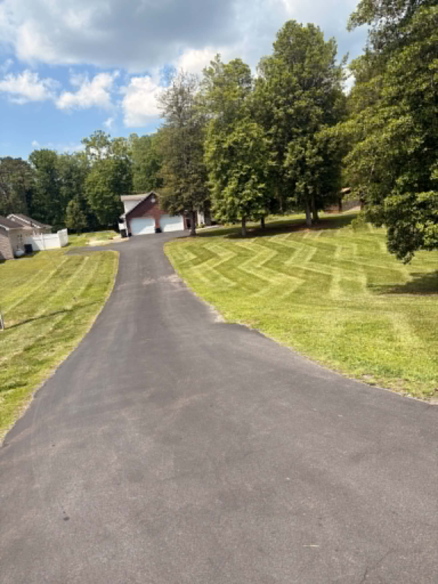 Professionally striped green lawn with My Buddy Lawn Care equipment on site