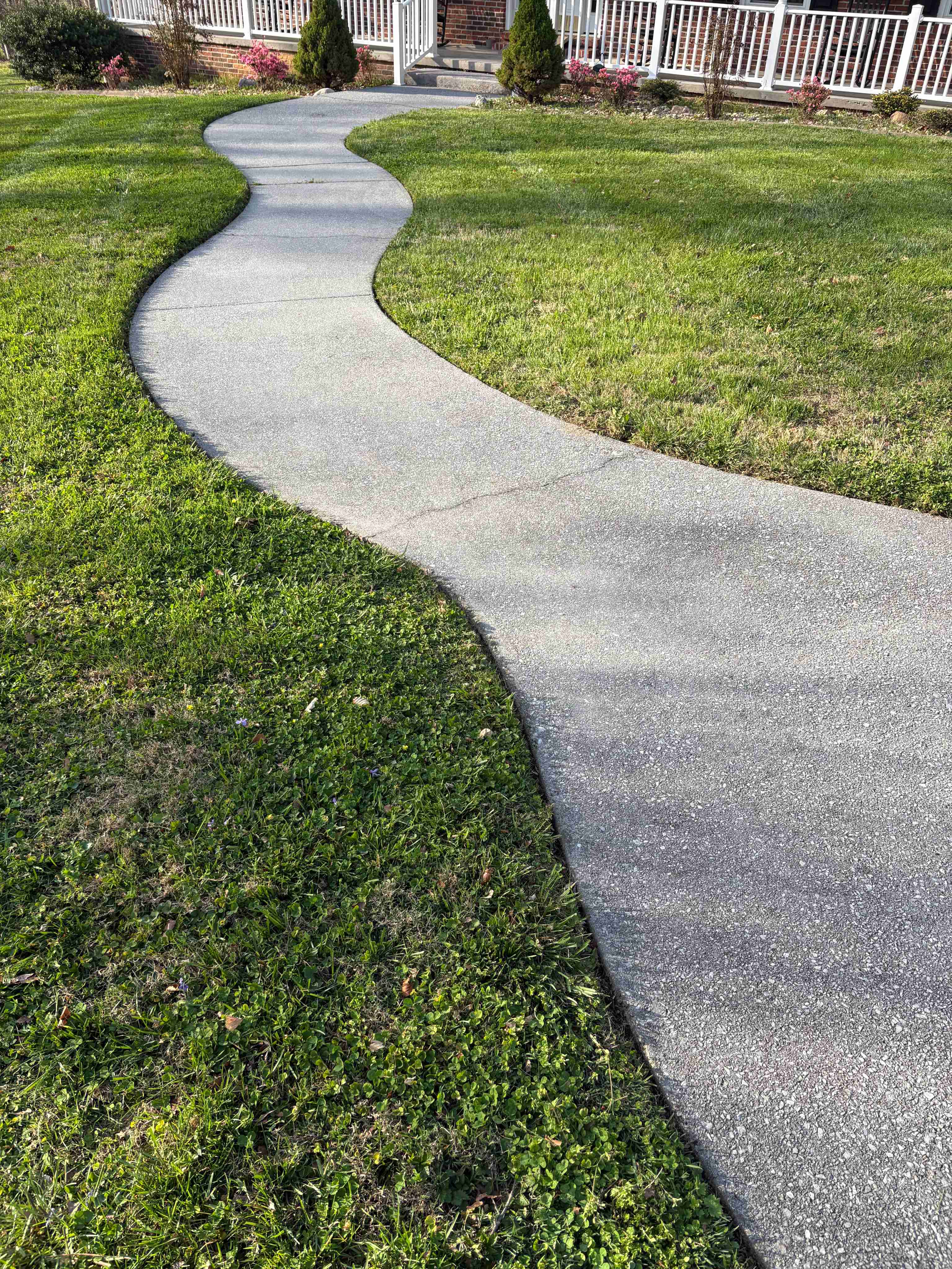 Walkway and shaped planted beds in a home landscape